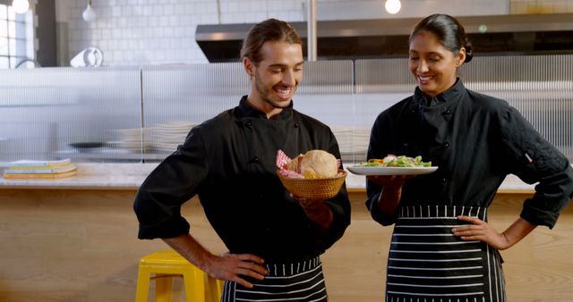 Chefs Wearing Uniforms Smiling and Holding Dishes at Restaurant Kitchen - Download Free Stock Images Pikwizard.com