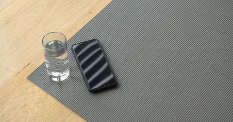 Minimalist Setup with Yoga Mat, Water Glass, Smartphone