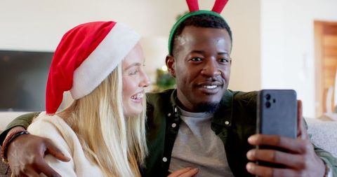 Joyful Interracial Couple Taking Holiday Selfie During Christmas Season