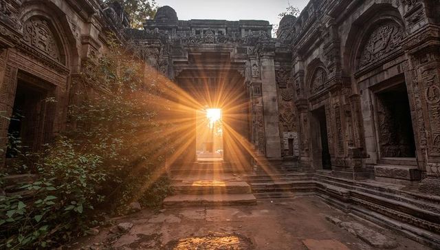 Sunburst Illuminating Ornate Stone Temple Portal at Golden Hour