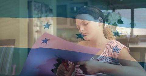 Young Girl Engaged in Crafting with Honduras Flag Overlay