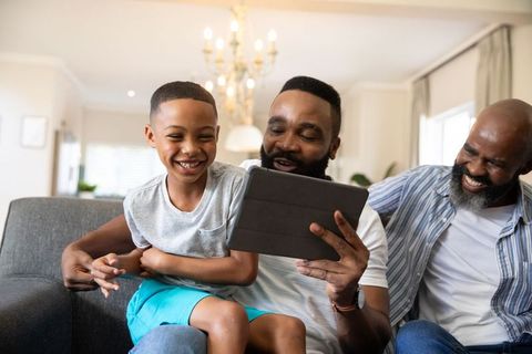 Family Bonding Moment with Grandfather and Son on Tablet