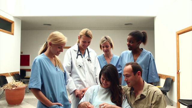 This depicts a joyful moment as new parents are surrounded by a supportive medical team in a hospital. Ideal for use in healthcare advertising, maternity ward promotions, family health brochures, or any materials focusing on childbirth, parenting, and family well-being.