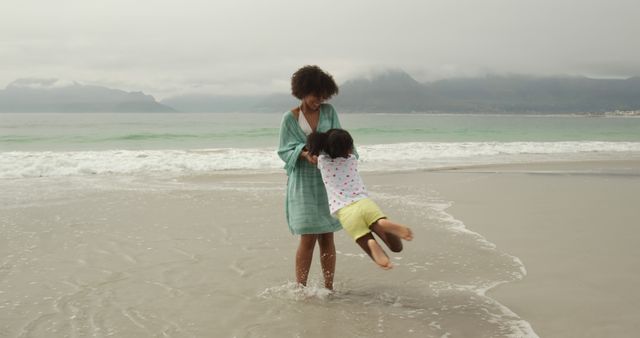 Smiling Mother Swinging Child on Beach - Download Free Stock Images Pikwizard.com