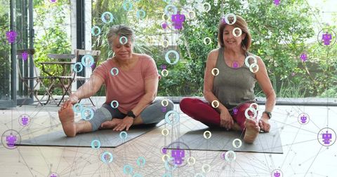 Mature women stretching on yoga mats by glass wall with garden and digital wellness overlay