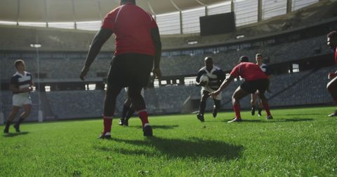 Rugby players competing energetically in sunlit stadium