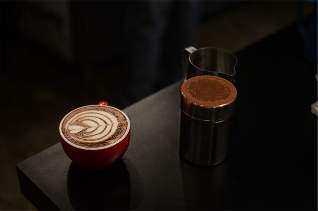 Coffee Latte Art with Cocoa Powder on Black Table - Download Free Stock Photos Pikwizard.com