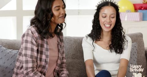 Two Women Celebrating Birthday with Laughter and Joy on Couch