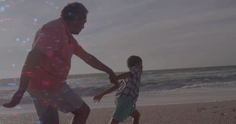 Grandfather and Grandson Running at Beach in Vibrant Light