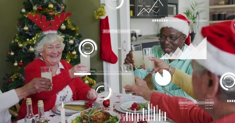 Seniors toasting at holiday dinner with santa hats, reindeer antlers, festive hud graphics