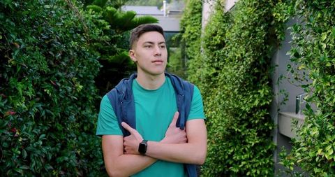 Man in garden path wearing smartwatch and hoodie