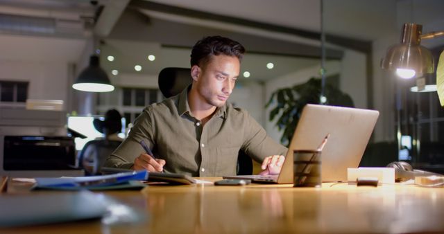 Businessman Working Late in Office on Laptop Under Warm Light - Download Free Stock Images Pikwizard.com