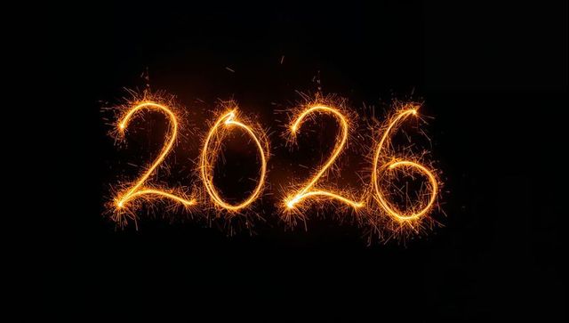 Glowing 2026 sparkler light painting with golden sparks on black background