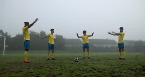 Soccer Players Warming Up on Foggy Field for Team Practice
