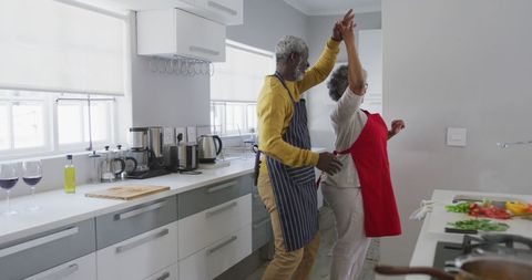 Senior African American Couple Joyfully Dancing in Kitchen