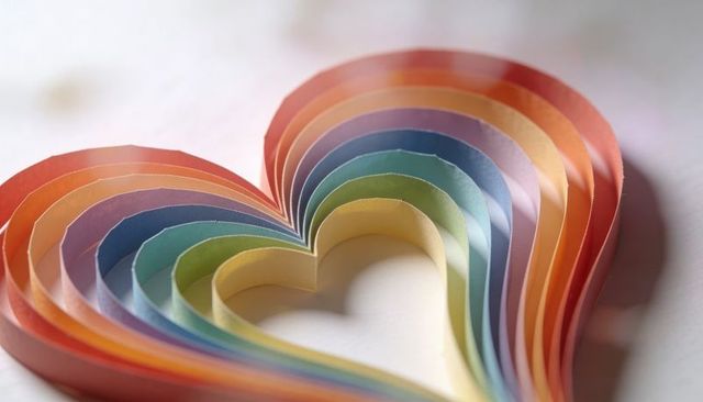 Layered rainbow paper heart showing concentric color spectrum and soft shadows