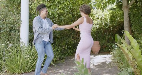Joyful couple dancing in garden celebrating special day