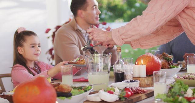 Image of happy caucasian parents, daughter and grandparents serving food at outdoor table. Family, domestic life and togetherness concept digitally generated image.