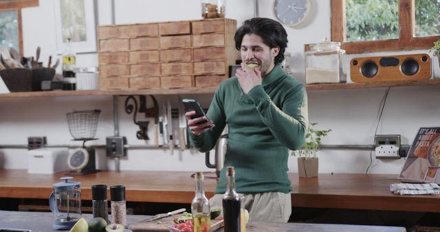 Man Snacking While Checking Phone in Modern Kitchen - Download Free Stock Images Pikwizard.com