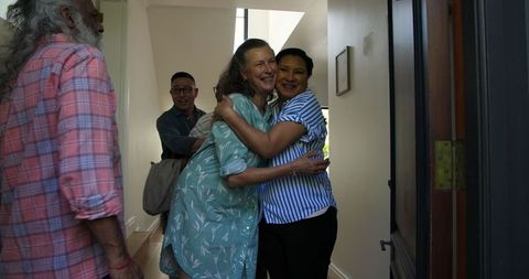 Diverse Senior Friends Hugging at Home Celebration