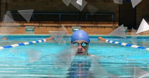 Competitive swimmer powering through lane wearing blue cap and mirrored goggles