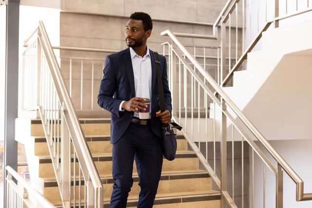 African American Businessman Walking Downstairs with Coffee and Smartphone - Download Free Stock Images Pikwizard.com