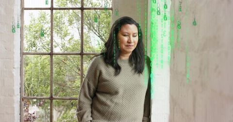 Woman leaning at metal window contemplating with green binary overlay and soft daylight