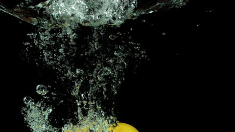 Lemons Splashing in Water with Bubbles and Ripples