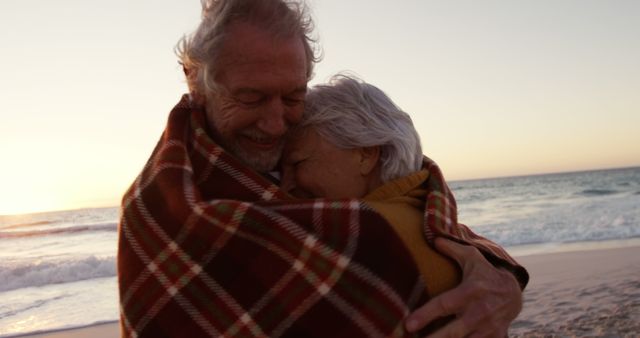 Senior Couple Embracing Under Blanket on Beach at Sunset - Download Free Stock Images Pikwizard.com