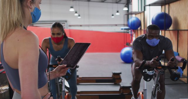 Personal Trainer Coaching Clients on Stationary Bikes at Gym - Download Free Stock Images Pikwizard.com