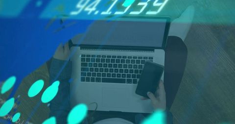 Woman tapping phone while using laptop with digital analytics overlays for remote work