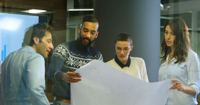 Diverse team of professionals review plans in an office. They collaborate on a project, sharing insights and strategies.