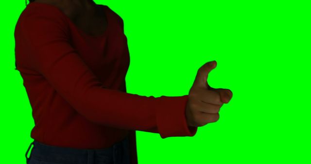 Woman giving a thumb's up in agreement or approval wearing a red shirt and isolated over a green screen background. This visual is useful for graphic designers, video editors, or content creators needing transparency to alter background or suggesting positivity. Ideal for promotional materials emphasizing approval or positive feedback.