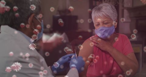 Senior doctor administering covid-19 vaccine to female patient