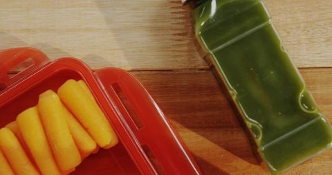 Fresh Baby Carrots with Green Juice in Rustic Kitchen Setting