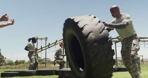 Male Soldier Flipping Tire During Intense Outdoor Training