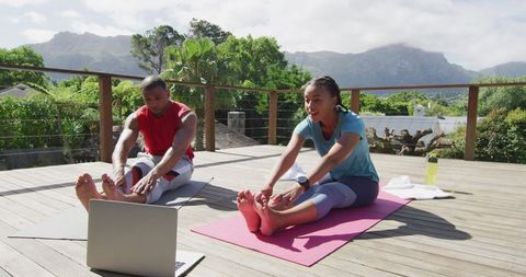 Couple Practicing Yoga on Outdoor Deck with Online Guidance
