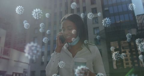 Woman talking on phone with lowered mask and floating virus concept