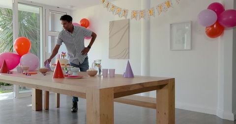 Man Preparing Birthday Table with Cake and Decorations at Home