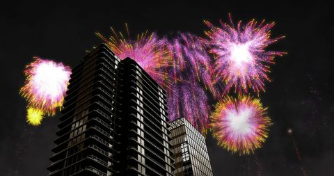 Vibrant Fireworks Over Modern Skyscrapers at Night