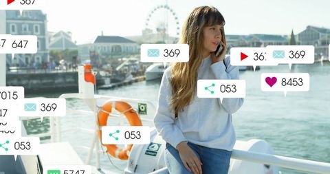 Woman Engaging on Smartphone by Harbor with Alerts Displayed