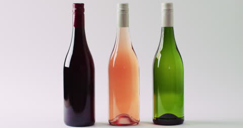 Three Varieties of Wine in Bottles on White Surface