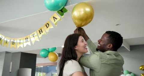 Happy Couple Decorating for Birthday Celebration at Home