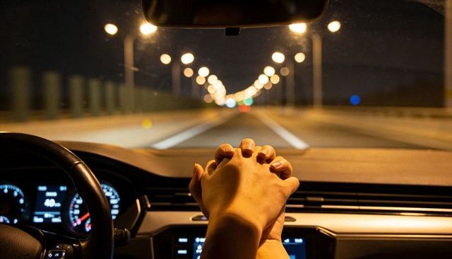 Couple holding hands on dashboard during romantic night drive intimacy and connection