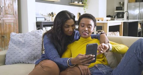 Mother and Daughter Bonding over Smartphone in Modern Living Room