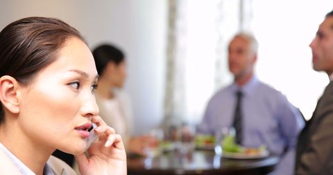Businesswoman Discussing Over Phone During Lunch Meeting
