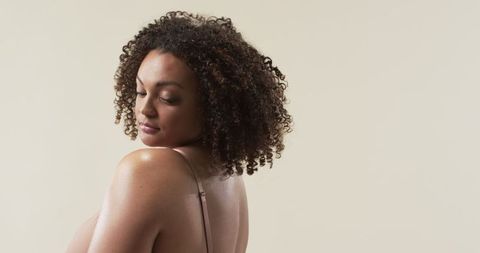 Confident Plus Size Woman with Natural Curls Smiling Gently