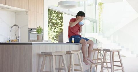 Young Man Enjoying Breakfast Moment in Modern Kitchen
