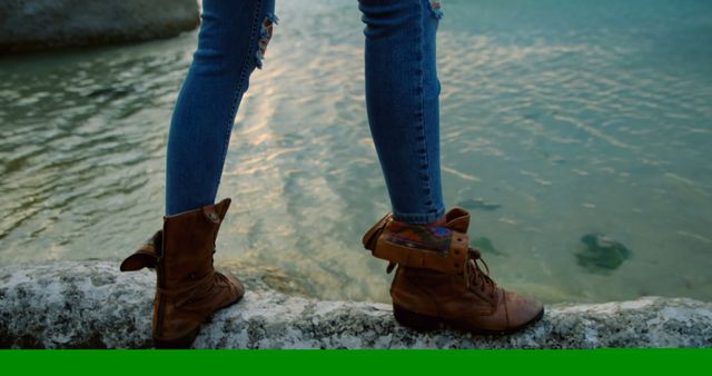 Female Hiker Standing by Lake Edge Wearing Distressed Jeans and Rustic Boots - Download Free Stock Images Pikwizard.com