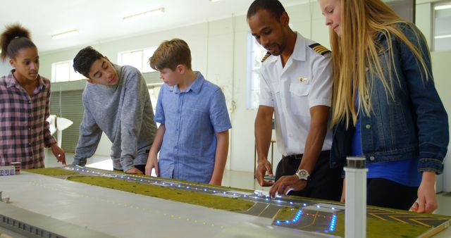 Instructor Showing Airport Model to Diverse Group of Teens in Classroom Setting - Download Free Stock Images Pikwizard.com